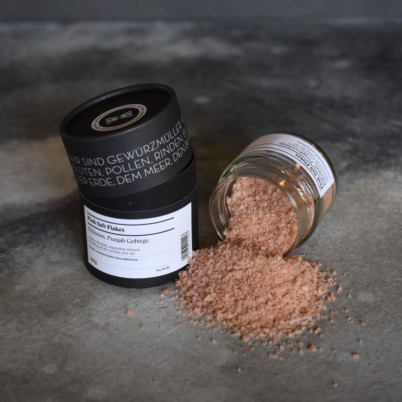 Pink Salt Flakes, Pakistan Pink salt flakes – offenes Gewürzglas mit Gewürzdose daneben