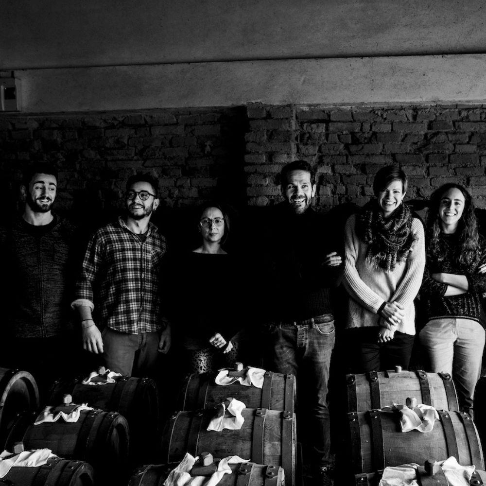 Balsamico BIO, Balsamela, Apfelbalsamessig Schwarz-weiß Gruppenfoto vor Balsamico Fässern