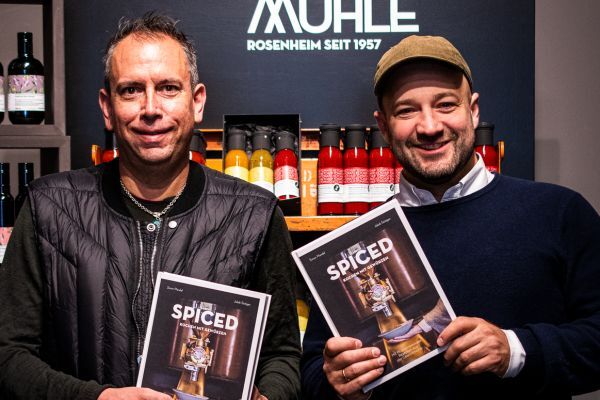 Simon Mendel und Jakob Stüttgen wie sie beide ein "SPICED" Kochbuch in der Hand halten