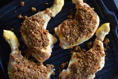 Rohe Hühnerkeulen gewürzt mit Baharat in Grillpfanne