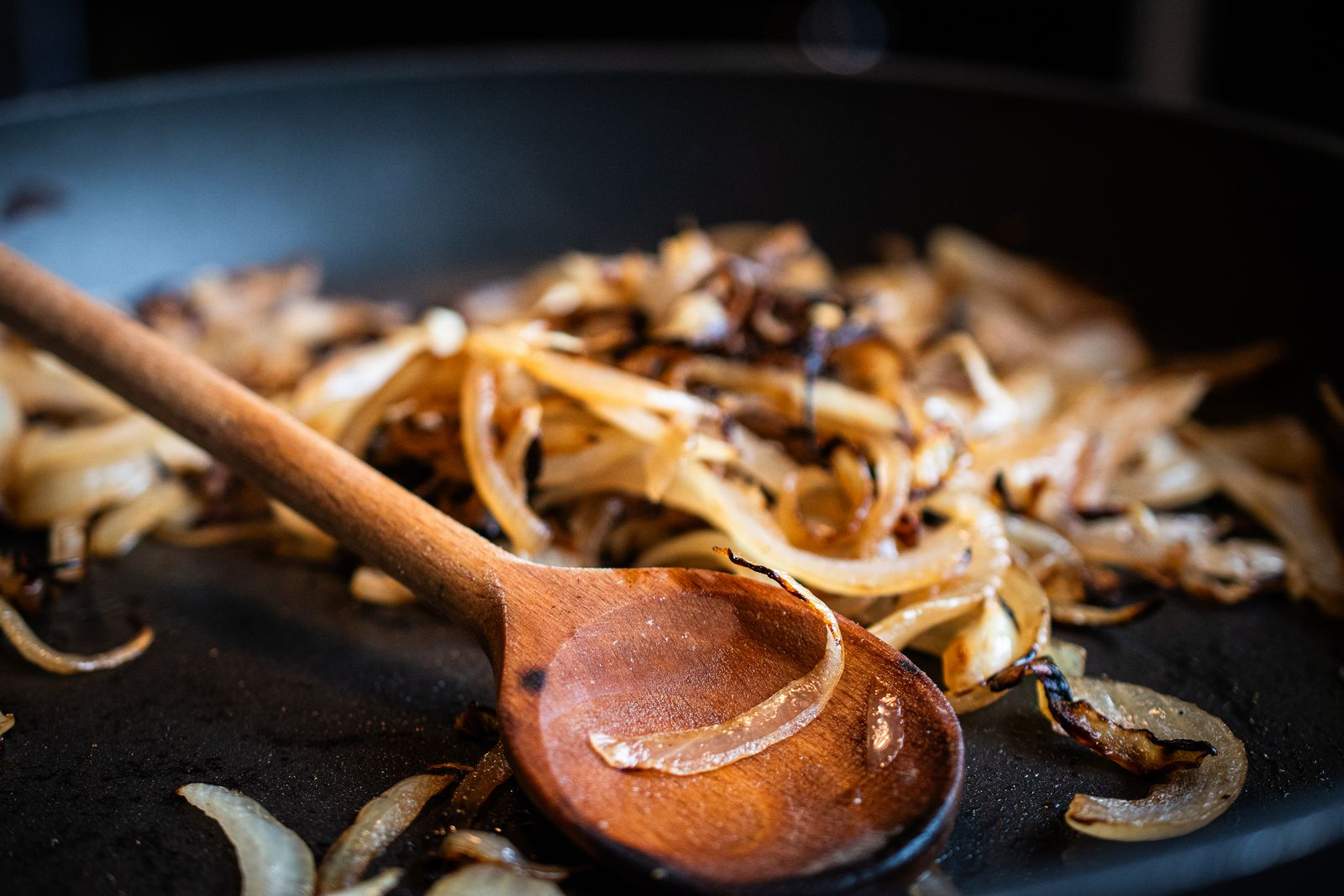 Angeschwitzte Zwiebeln in Pfanne mit Holzlöffel von Gewürzmühle Rosenheim