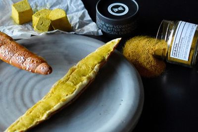 Brot mit Café-de-Paris-Gewürzbutter, im Hintergrund Butterwürfel und Gewürzdosen