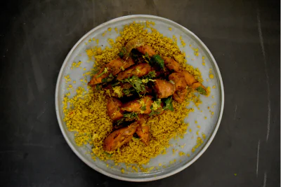 Couscousgericht auf einem Teller, von oben fotografiert.