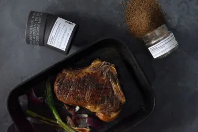 Fertiges Steak, daneben zwei Gewürzdosen, von oben fotografiert
