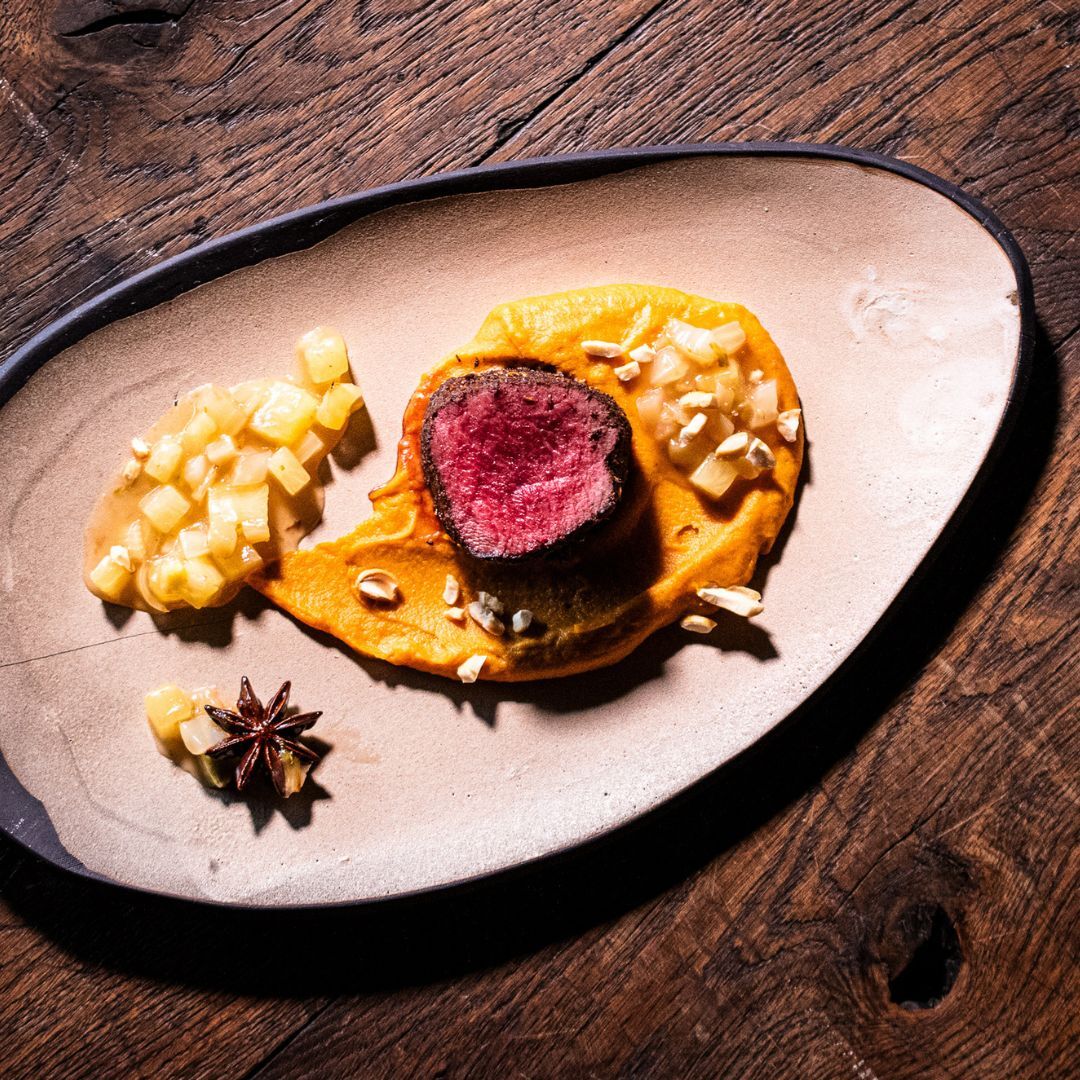 Rehrücken gewürzt mit dem Five Spice Gewürz auf einem Teller angerichtet mit Süsskartoffelcreme und Ananas-Fenchel-Sud.