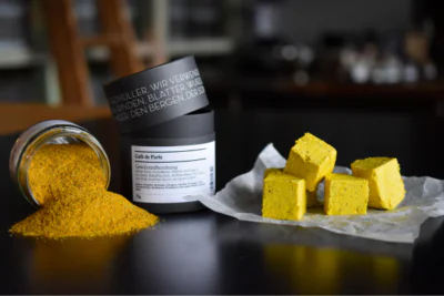 Ausgeschüttetes Café de Paris Gewürzglas neben mehreren Würfeln Gewürzbutter