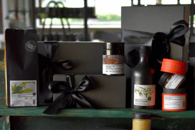 Mehrere Gewürzdosen rechts, und Geschenkboxen links, auf einem Tisch-
