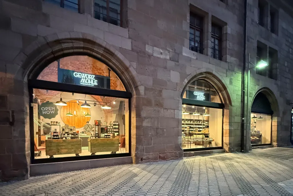 Außenansicht drei beleuchtete Schaufenster Gewürzladen in Nürnberg