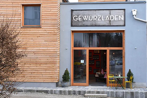 Ladenfront des Gewürzladens in Stephanskirchen mit einem Tisch und zwei Stühlen vor der Tür