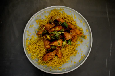 Couscousgericht auf einem Teller, von oben fotografiert.