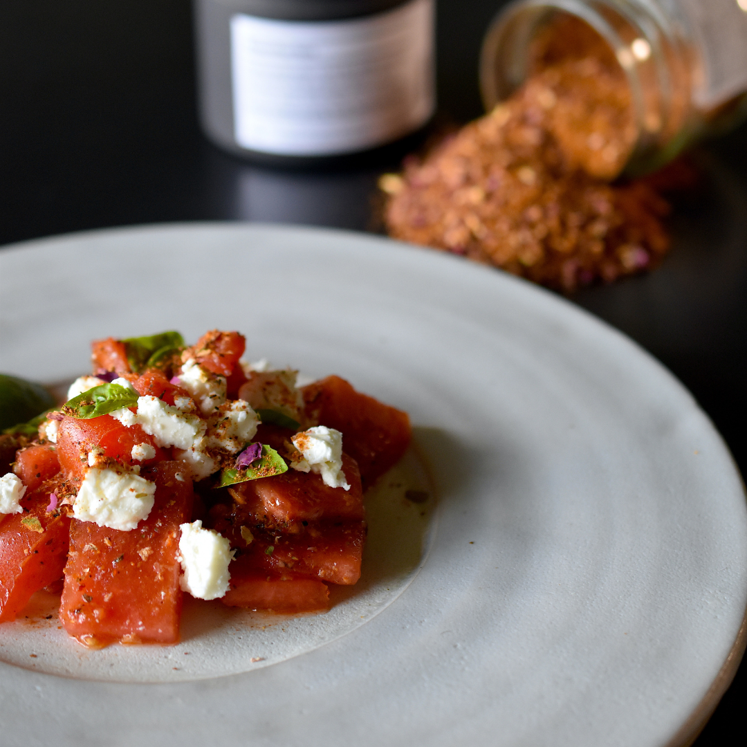 Rosenharissa Wassermelonen Salat gewürzt mit Rosenharissa, serviert auf einem Teller