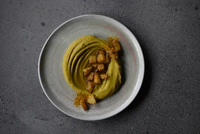 Hummus-Gericht auf einem Teller, von oben fotografiert.