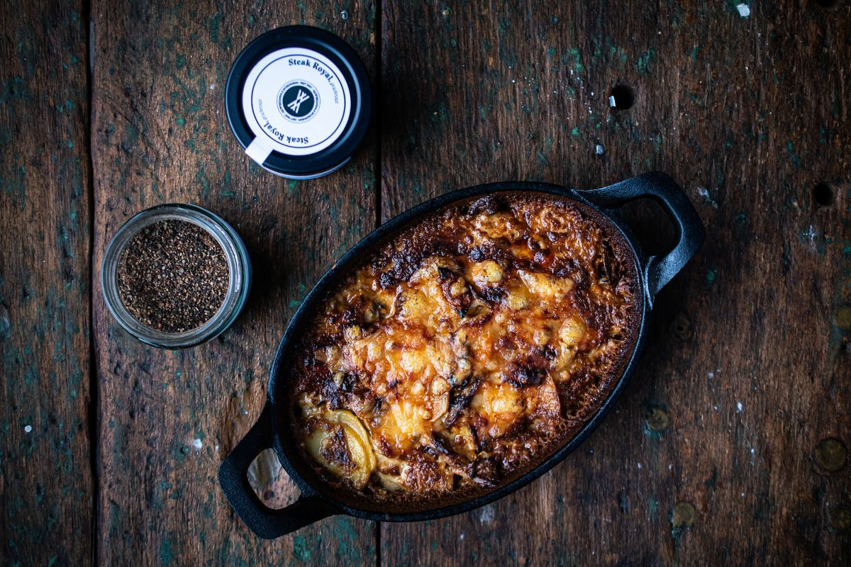 Kartoffelgratin mit Zwiebeln und Comté in gusseiserner Pfanne neben Steak Royal Gewürz von Gewürzmühle Rosenheim