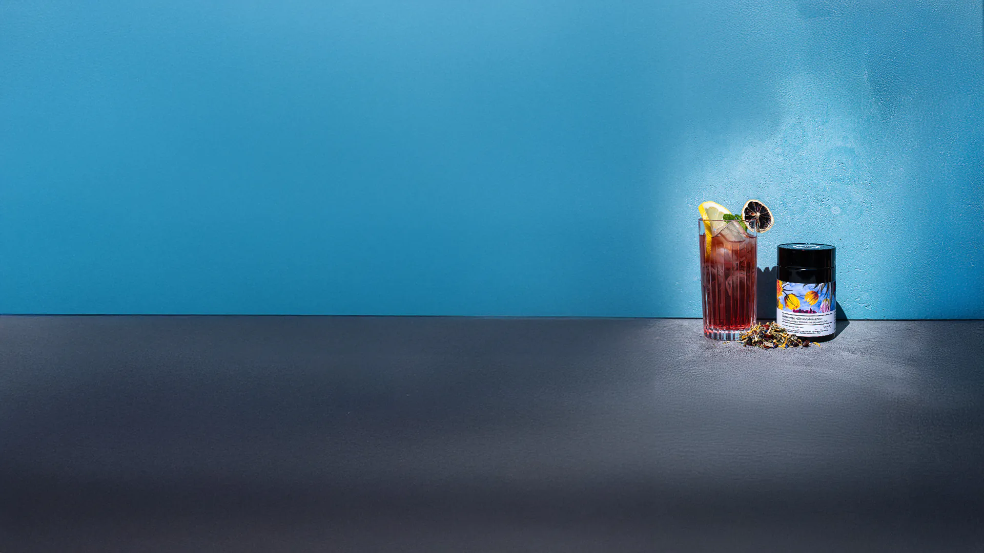 gm-header-eistee_2025 Kalter Eistee und Kräutertee vor blauer Wand