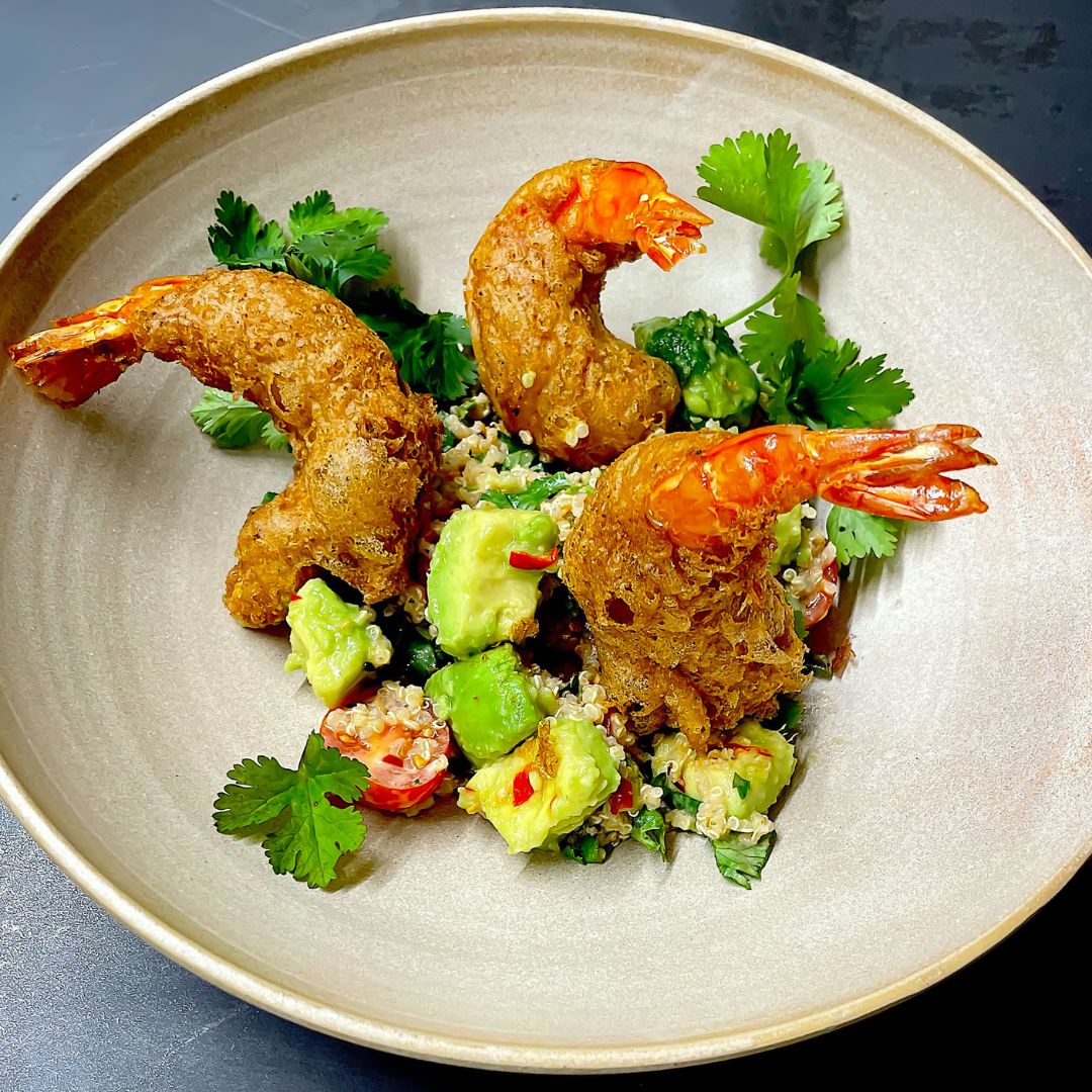 Knusprig frittierte Garnelen auf einem frischen Quinoa-Avocado-Salat mit Kräutern und Chili. Ein Gericht inspiriert von den Aromen der Gewürzmühle Rosenheim.